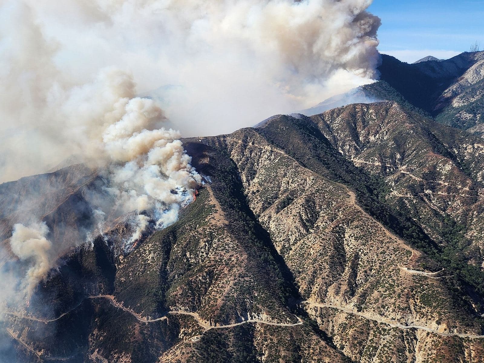 Smoke from the Eaton Fire rising over the ridges of the San Gabriel Mountains.