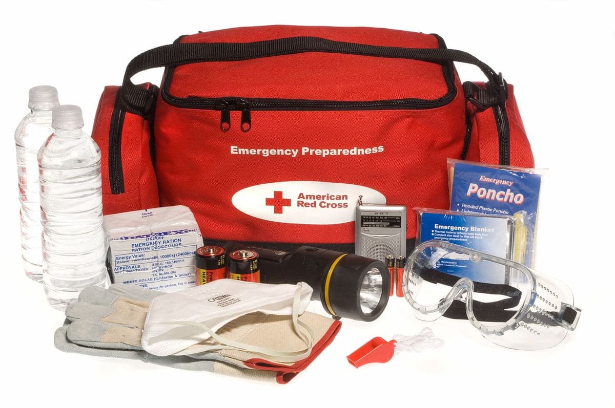 An emergency supply bag with water bottles, a flashlight, batteries, gloves, goggles, a whistle and a poncho.